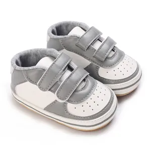 Détail rapproché des baskets pour bébé grises et blanches avec fermeture à scratchs