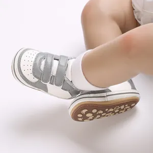 Gros plan de baskets bébé bicolores avec semelles antidérapantes et des scratchs