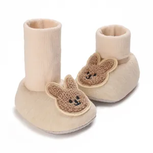 Chaussons bébé en tricot beige avec écusson lapin en peluche et revers en côtes souples