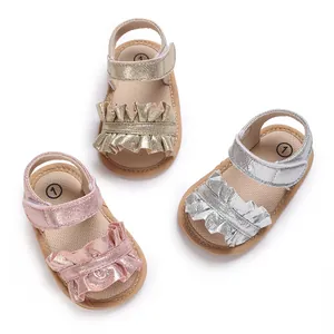 Detail view of soft-sole metallic baby girl sandals with ruffles in gold silver and pink