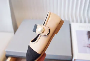 Primer plano de zapatos de princesa Mary Jane para niña con perla elegante y punta en contraste.