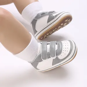 Vue détaillée de baskets pour bébé grises et blanches avec double fermeture scratch.