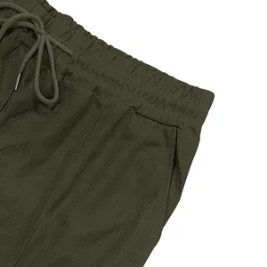 Dettaglio del pantaloncino verde oliva con trama a nido d'ape e coulisse in vita