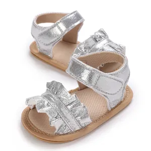 Close-up of silver baby girl sandals with ruffle trim and soft anti-slip sole.