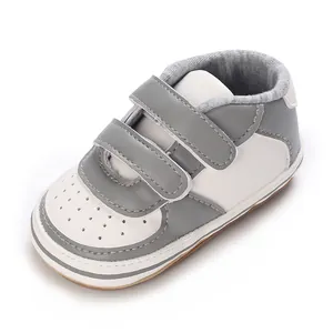 Gros plan détaillé de baskets pour bébé gris et blanc avec double bande auto-agrippante