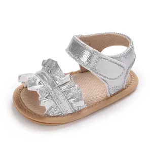Close-up of silver ruffled baby girl sandals with soft non-slip sole and velcro strap closure