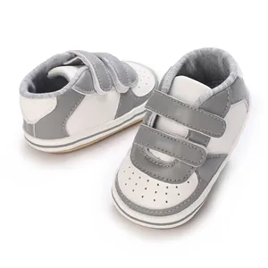 Vue détaillée de baskets pour bébé bicolores gris et blanc avec bandes velcro