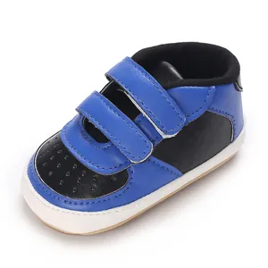 Vue détaillée de chaussures de sport pour bébé bleues et noires à double velcro.