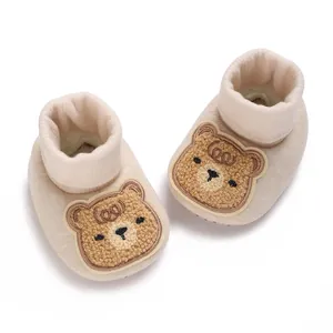 Chaussons bébé beiges doux avec un motif d'ours mignon et des revers côtelés confort