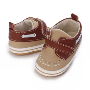 Nahaufnahme von weichen Baby-Lauflernschuhen in Braun und Beige mit Klettverschluss