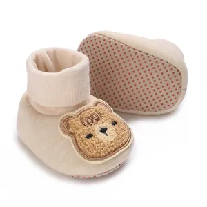 Vue détaillée de chaussures de marche bébé crème avec ours en peluche et semelle antidérapante