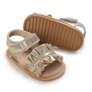 Close-up of gold glitter baby girl sandals with ruffled straps and soft sole