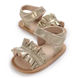 Detail view of gold ruffled baby girl sandals with soft non-slip soles for walking.