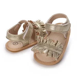 Close-up of gold baby girl sandals with ruffles and soft non-slip soles