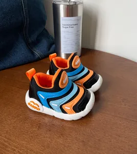 Detailweergave van ademende rupssneakers voor babyjongens in oranje en blauw.