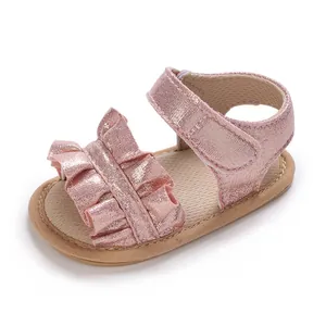 Detailed shot of sparkly pink baby girl sandals with ruffles and soft non-slip sole.