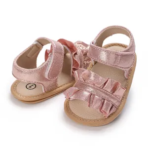 Close-up detail of pink glittery baby girl princess sandals with ruffles and soft non-slip soles