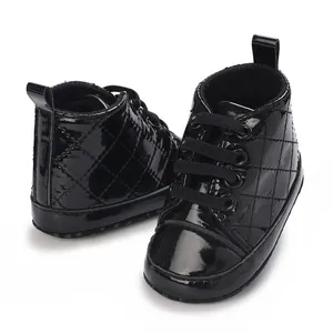 Detail von schwarzen gesteppten Lackleder-Babyschuhen mit weichen Sohlen zum Laufen