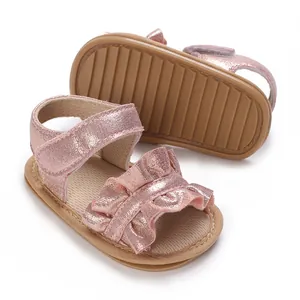 Close-up of rose gold ruffled baby sandals with anti-slip soft soles
