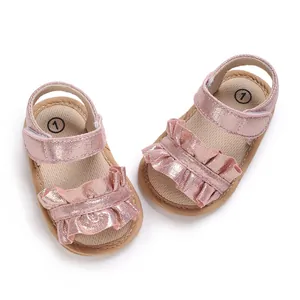 Close-up of pink ruffled metallic baby girl princess sandals with soft non-slip toddler soles