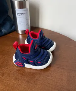 Zijaanzicht van donkerblauwe baby-loopschoenen met flexibele zolen op houten tafel