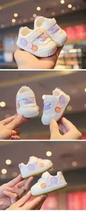 Dettaglio delle scarpe primi passi per neonati con disegni di smiley colorati
