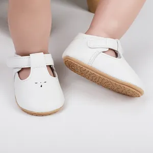 Detailed view of white baby walking shoes with cat design and non-slip rubber sole