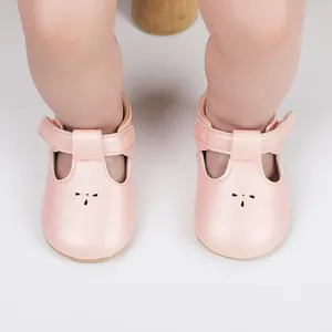 Detail view of pink soft-sole baby walking shoes featuring T-strap design and velcro closure