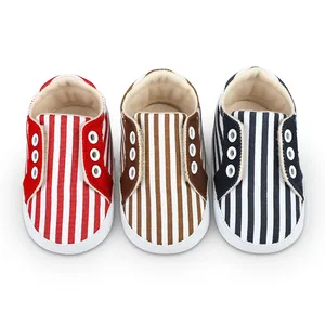 Vue de dessus de trois paires de chaussures de marche rayées pour bébé en rouge et bleu