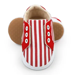 Gros plan de chaussures de marche pour bébé à rayures rouges et blanches, semelle antidérapante