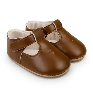 Close-up of brown synthetic leather baby walker shoes with T-strap and perforated flower detail