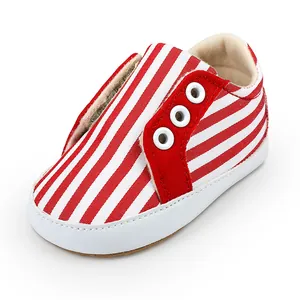 Gros plan de chaussures de marche pour bébé à rayures rouges et blanches avec semelle