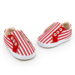 Vue détaillée des chaussures de marche bébé en toile rayée rouge et blanc avec semelles souples