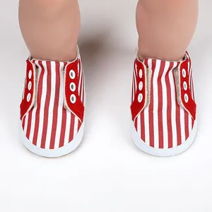Gros plan sur des chaussures de marche pour bébé en toile à rayures rouges et blanches.