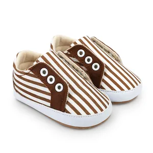 Détail des chaussures de marche rayées marron et blanc pour bébés âgés de 0 à 1 an