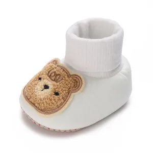 Gros plan détaillé d'un chausson chaussette pour bébé avec un patch d'ours brodé mignon