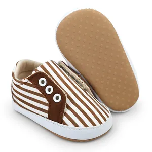 Détail de chaussures de marche bébé à rayures marron avec semelle en caoutchouc antidérapante