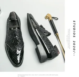 Vue détaillée des mocassins noirs à paillettes pour hommes avec bout fleuri et glands.