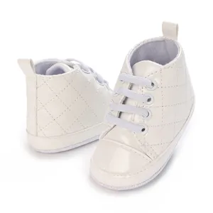Nahaufnahme weißer gesteppter Baby-Lauflernschuhe aus Lackleder mit weicher Sohle