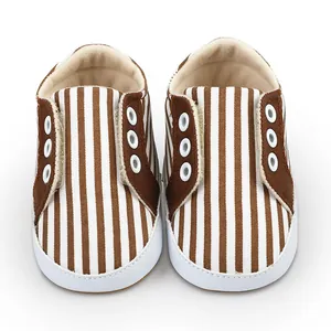 Vue détaillée de chaussures souples pour bébé avec rayures verticales marron et blanc