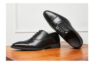Detailansicht von eleganten schwarzen Leder-Oxfordschuhen auf einer Holzoberfläche.