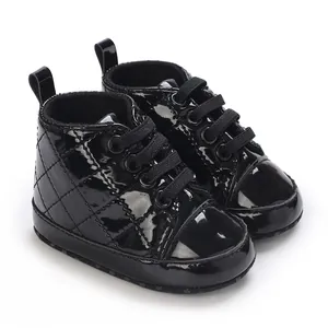 Nahaufnahme von schwarzen Lackleder-Babyschuhen mit gestepptem Muster für Jungen