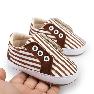 Gros plan de chaussures de marche pour bébé à rayures marron pour les 0-1 an.