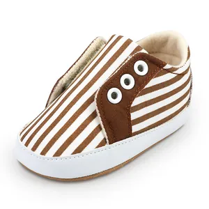 Gros plan détaillé de chaussures de marche pour bébé à rayures marron et blanc