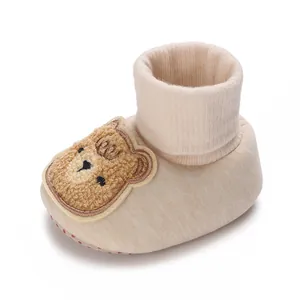 Vue détaillée de chaussures chaussettes de bébé beiges avec broderie ours