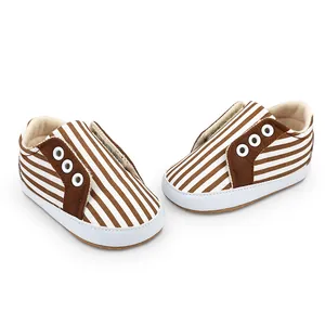 Vue détaillée des chaussures de marche pour bébé à rayures marron et blanches