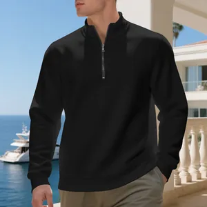 Felpa da uomo nera con mezza zip presentata in un rilassante ambiente esterno sulla spiaggia