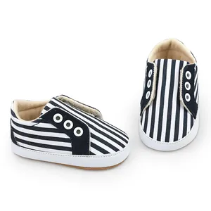 Détail des chaussures de marche pour bébé à rayures bleu marine avec texture canevas