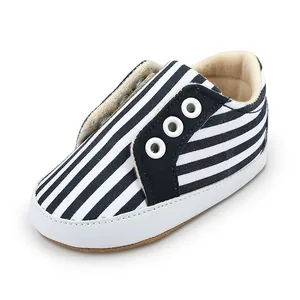Détail des chaussures de marche pour bébé à rayures bleu marine et blanc