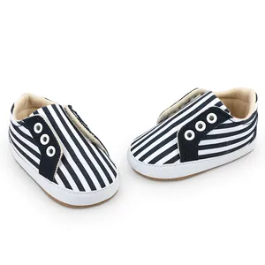 Gros plan de chaussures de marche pour bébé à rayures bleu marine et blanc, 0-1 an